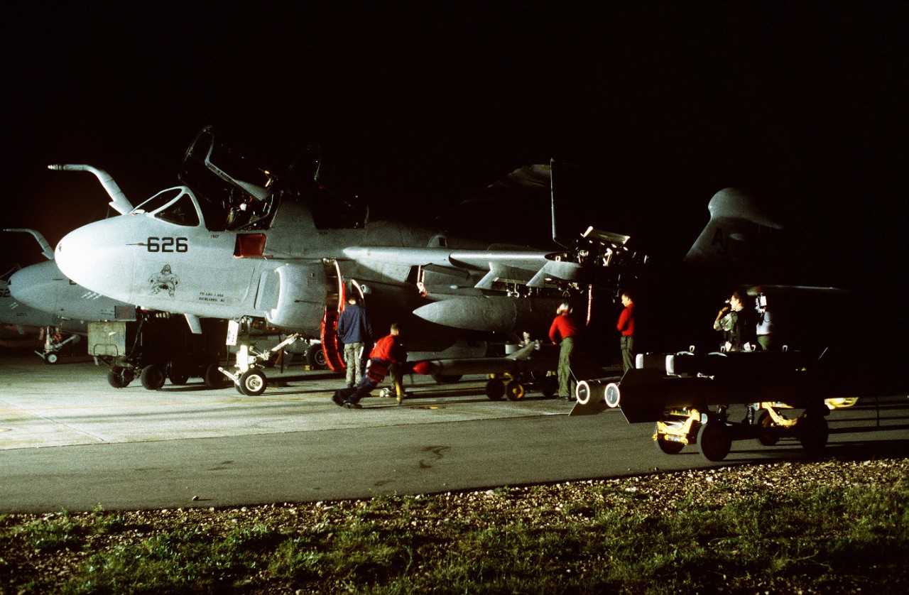 Crew load missiles on plane in the dark. 