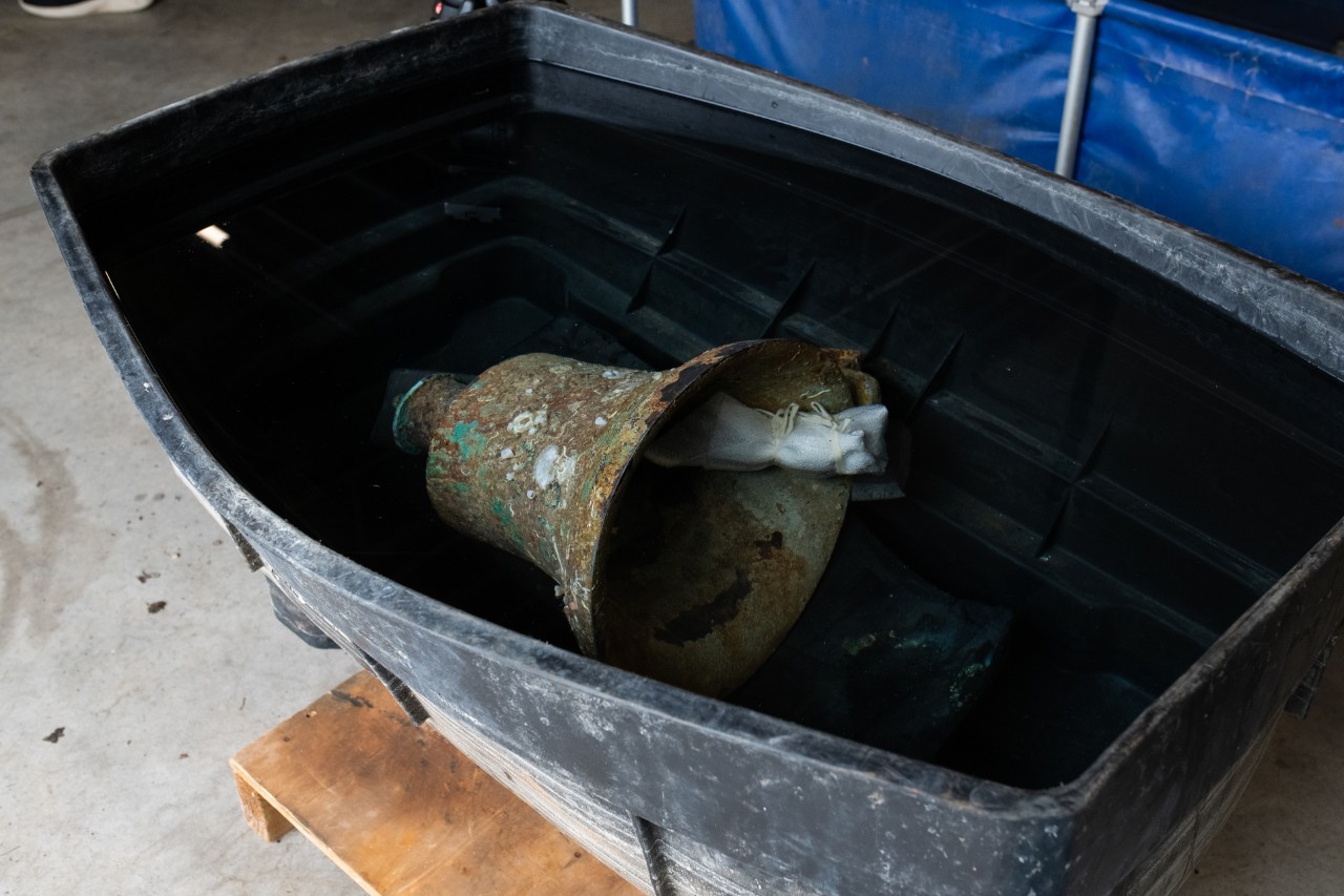 The ship’s bell of USS Jacob Jones (DD 61) in a tub of water at Wessex Archaeology in Salisbury, England, May 14, 2024