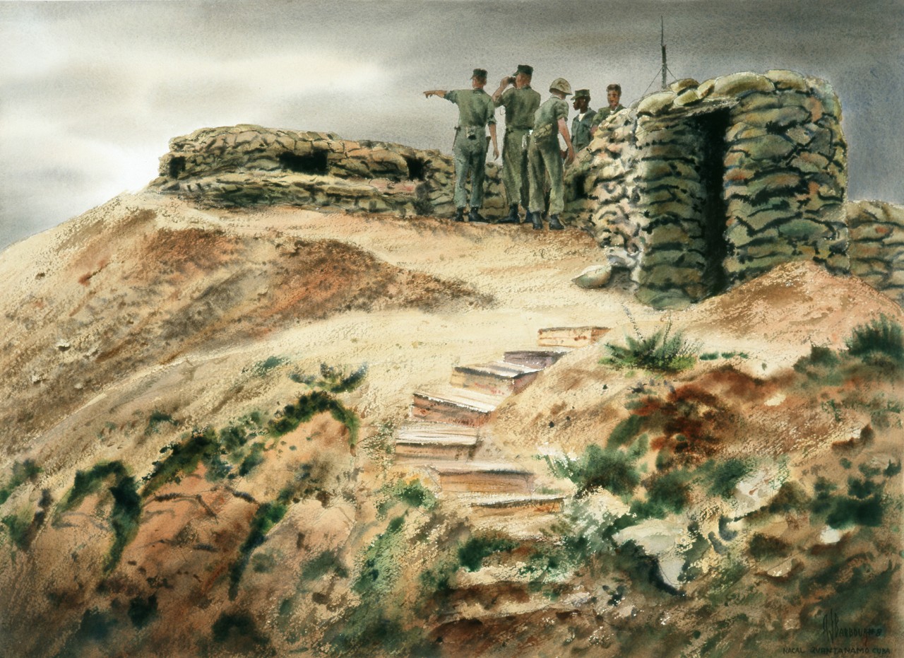 A group of Marines on top of a fortified hill looks out over the horizon
