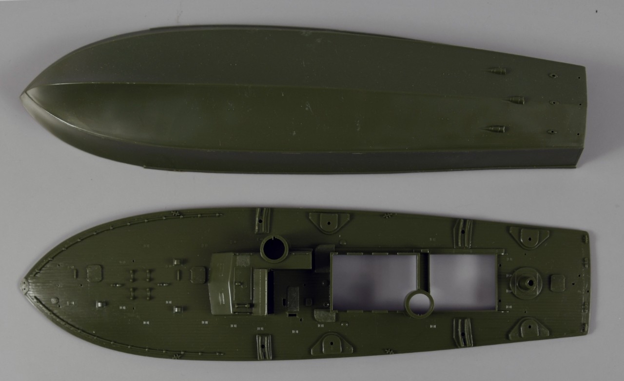 Two pieces of dark green plastic model hull for a torpedo patrol boat.