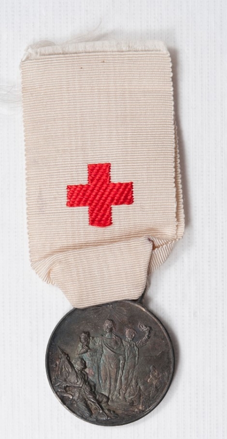 White ribbon with red cross and medallion marking earthquake relief in Italy 1909