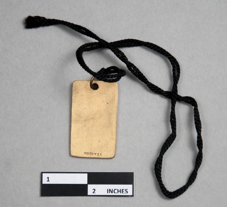 Rectangular brass pendant with black string.