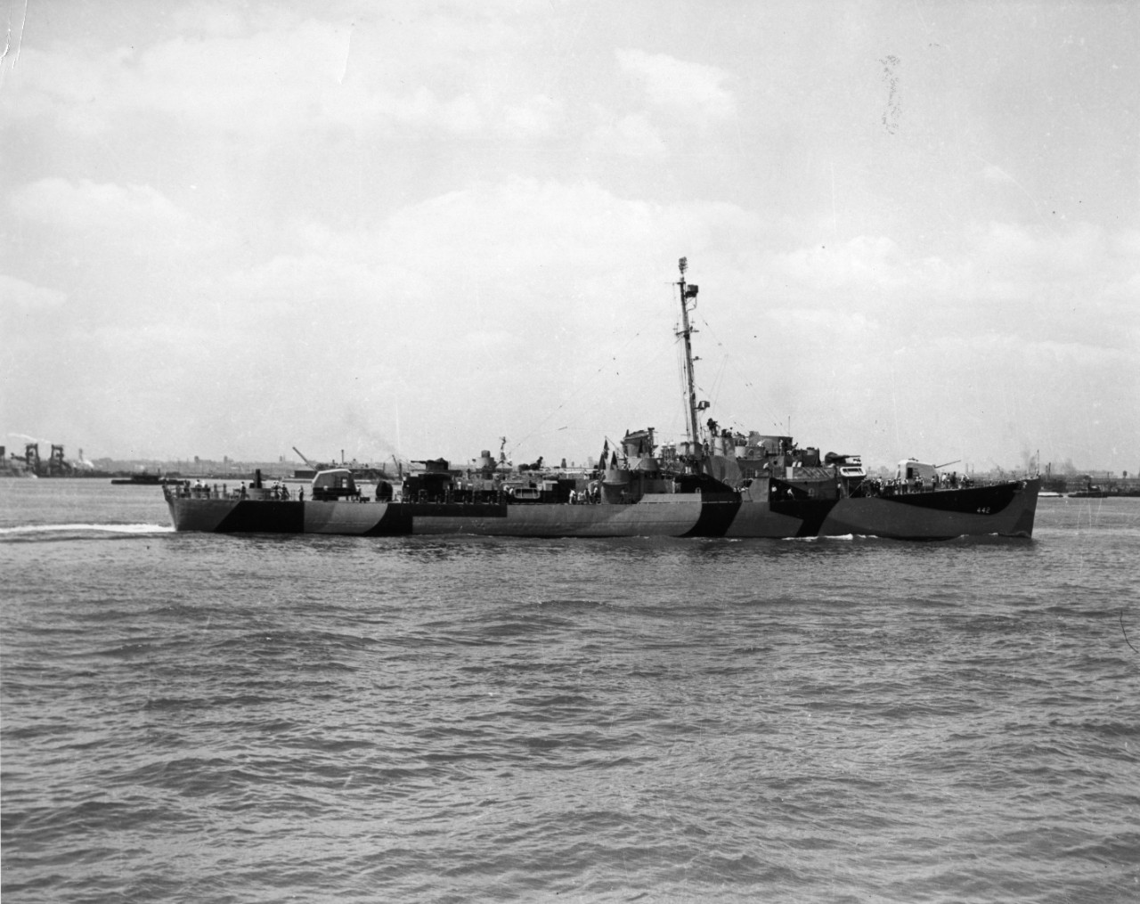 Starboard broadside view of destroyer escort USS Ulvert M. Moore (DE-442) underway, hull painted camouflage.