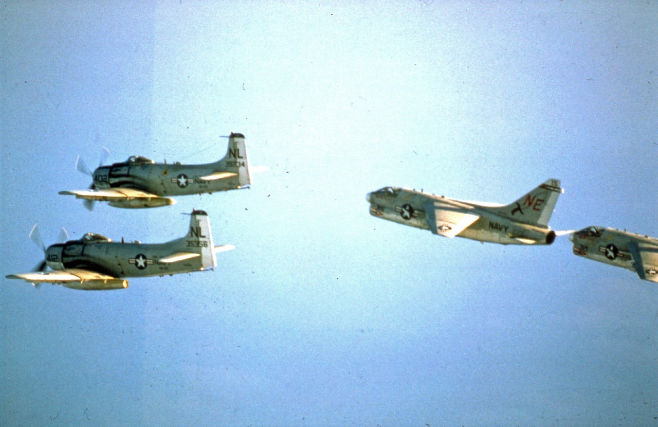 Two A-1 Skyraider attack aircraft and two A-7 Corsair II attack aircraft over the Gulf of Tonkin head toward North Vietnam on a combat mission following their takeoff from the attack aircraft carrier USS Coral Sea (CVA-43), January 1968.
