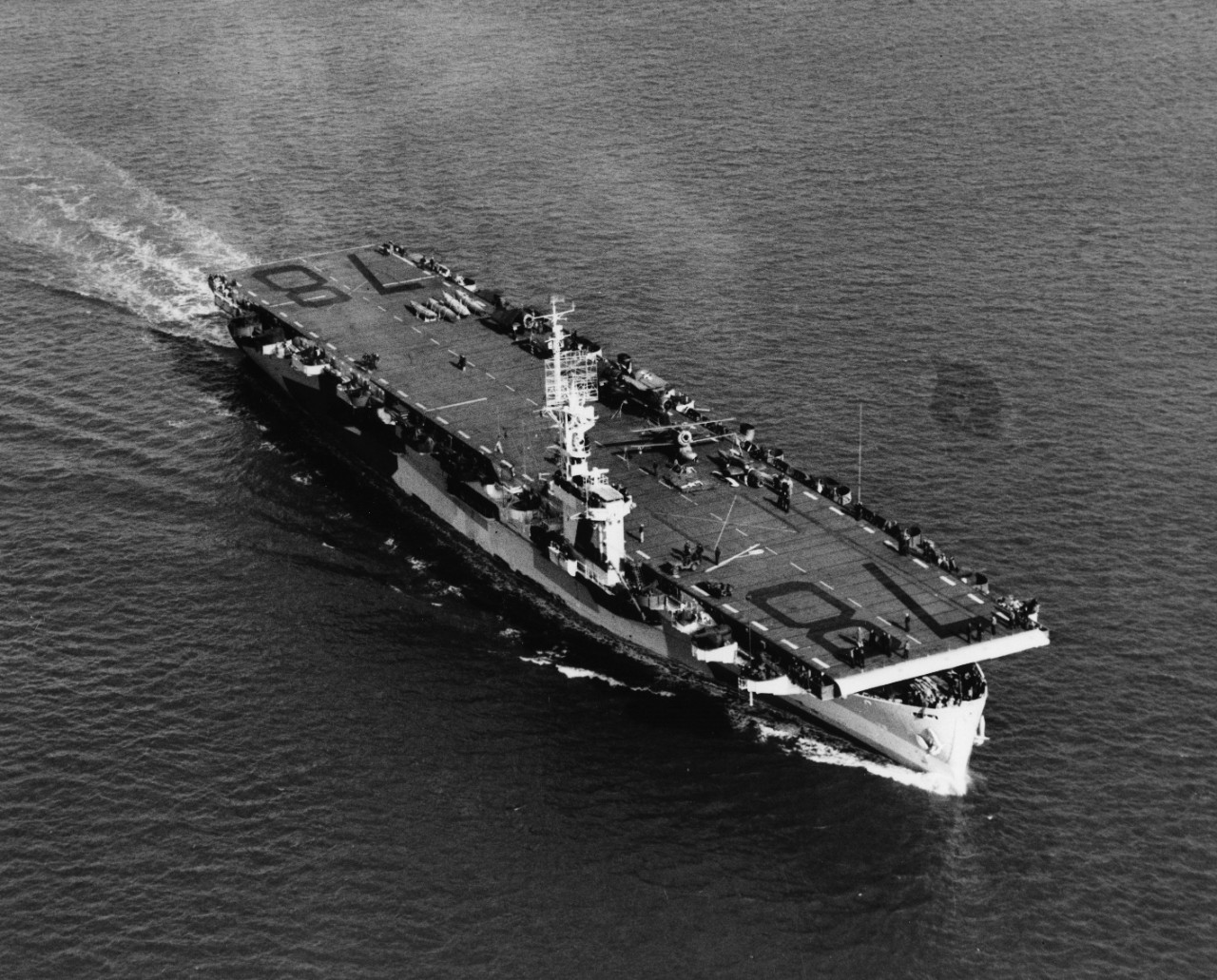 Starboard bow aerial view of Casablanca-class escort carrier USS Savo Island (CVE-78) underway. Note disassembled aircraft on the flight deck, and camouflage paint scheme.