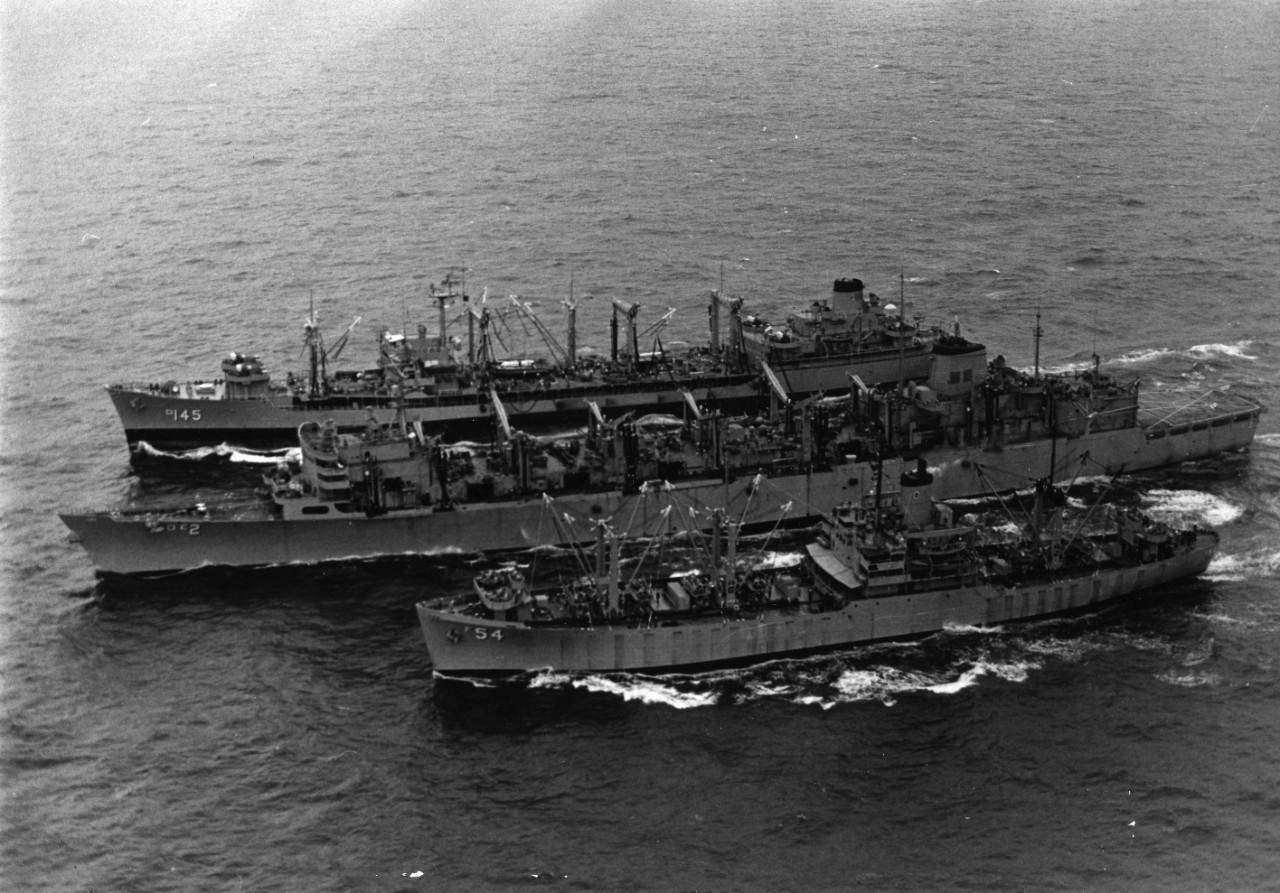 USS Pictor (AF-54), in the foreground, highlines cargo to USS Camden (AOE-2), center, while USS Hassayampa (AO-145) replenishes the Camden's liquid cargo.