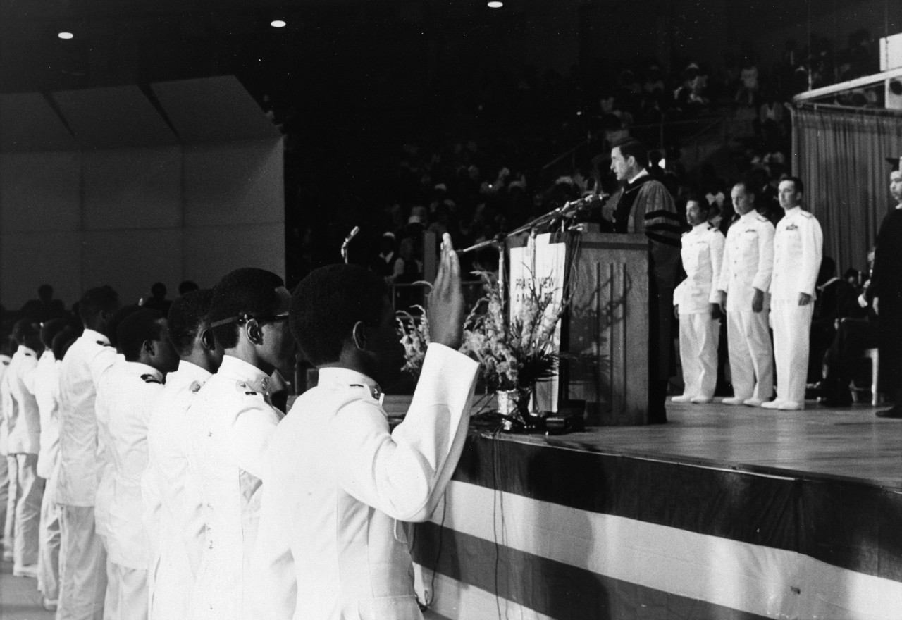 Secretary of the Navy John H. Chafee administers the commissioning oath to the members of the first graduating class from the Naval Reserve Officers Training Corps at Prairie View A and M College.