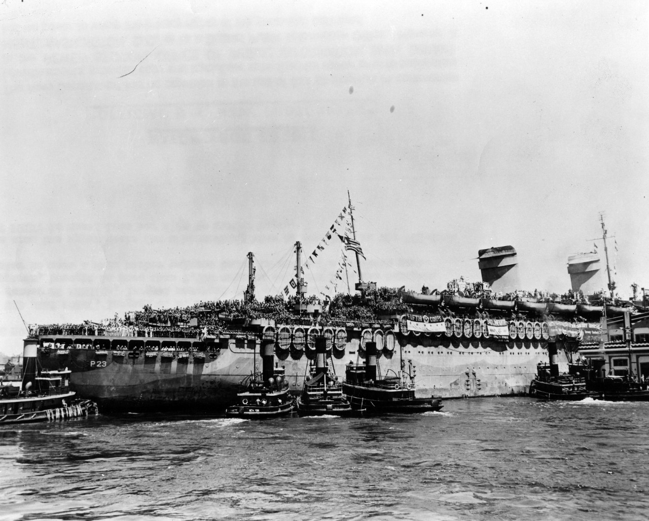 The USS West Point (AP-23), largest US Navy transport afloat, arrives in New York. The former SS America, largest merchant ship ever constructed in American shipyards, brought in more than 7,500 veteran soldiers from the European theater to meet a warm harbor welcome today in America's greatest port. GI's cram the upper decks for a homecoming view of New York as the 723-foot West Point is nosed into her slip by harbor tugs. July 11, 1945. 