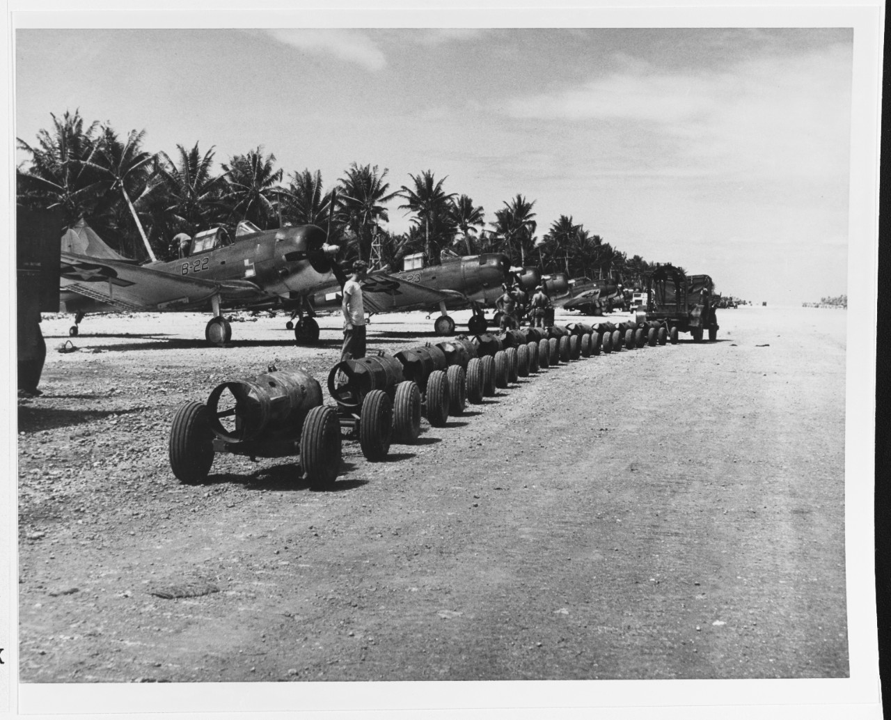 Majuro Island, Majuro Atoll, Marshall Islands. Bombs are wheeled up to the flight line, to be loaded on the SBD-5 bombers parked there, March 1944. Photographed by Lieutenant Commander Charles Kerlee, USNR.