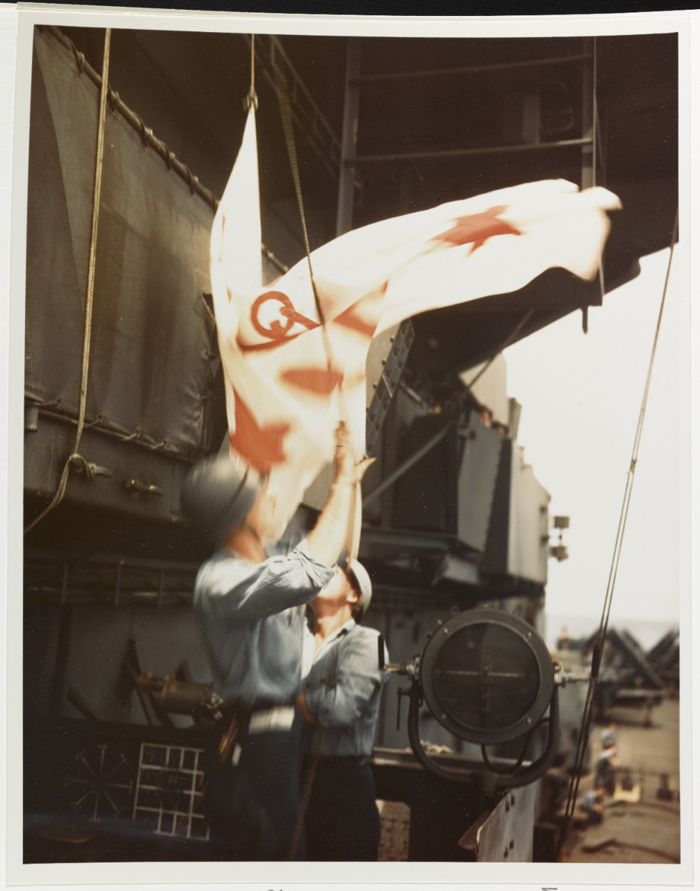 USS SHANGRI-LA (CV-38) Sailors haul down Assistant Secretary of the Navy John L. Sullivan's flag, 2 July 1945