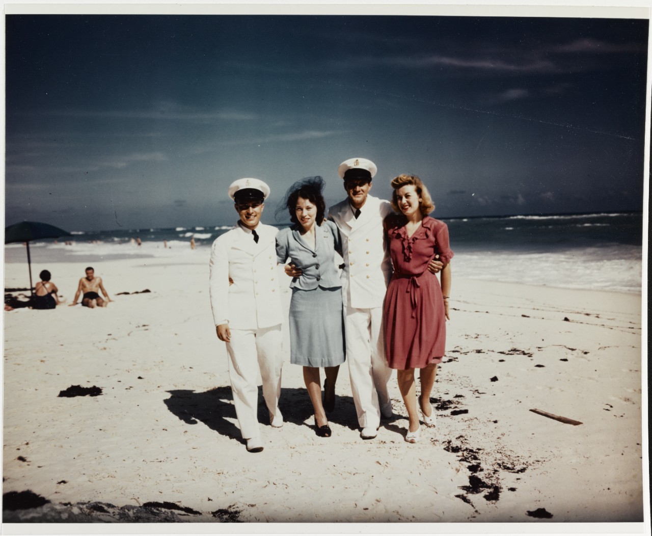 Two Chief Petty Officers walk with their wives, on a Bermuda beach, circa late 1945