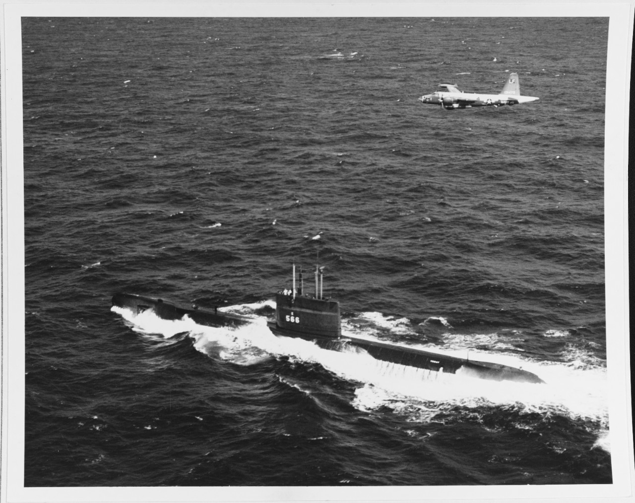 A P-2H "NEPTUNE" Patrol Plane of Patrol Squadron 16 flies over USS TROUT (SS-566)