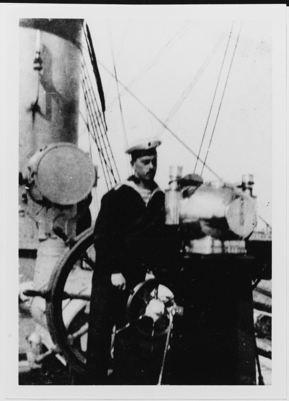 Russian sailor at the helm of the Training Ship VOIN, about 1910