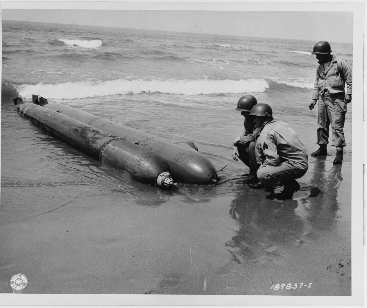 Torpedo attached to its driving compartment of this one-man submarine, beached