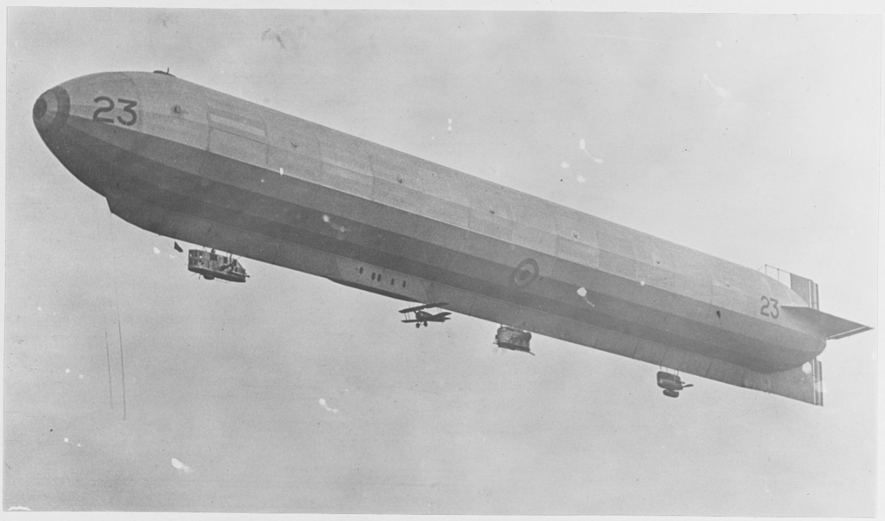 British Dirigible R-23 carrying fighting aeroplane suspended underneath huge gas bag