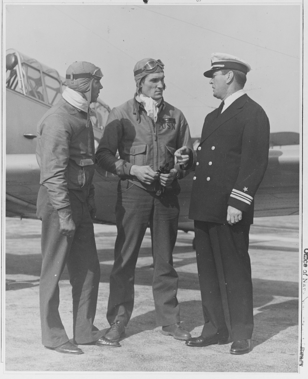 Lt. Comdr. J. J. (Gene) Tunney the Navy new athletic director, talking to cadets B.T. rude and D.M. Harmon at the Naval Air Station, Pensacola Fla.