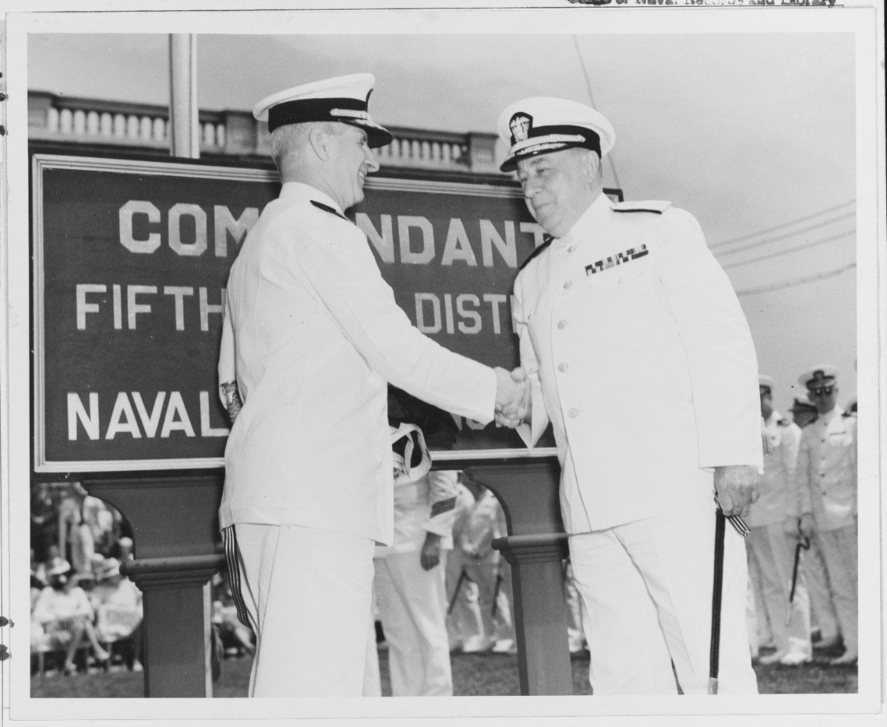 Rear Admiral Joseph J. Tausig, USN at left, greets Rear Admiral Manly H. Simons, USN