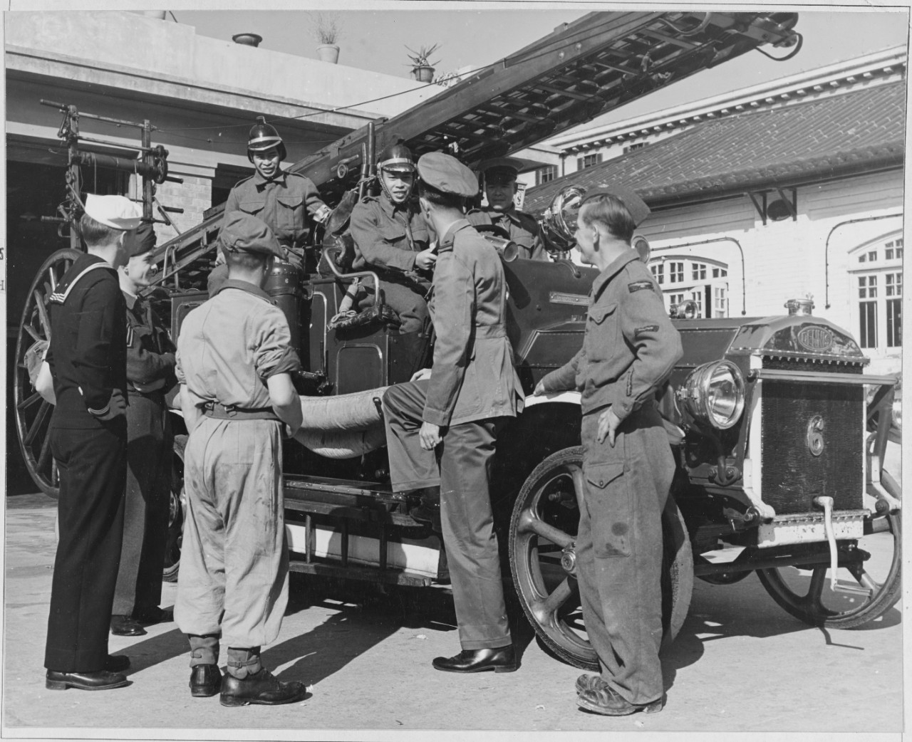 British and American service personnel talk with the Hong Kong Fire Brigade