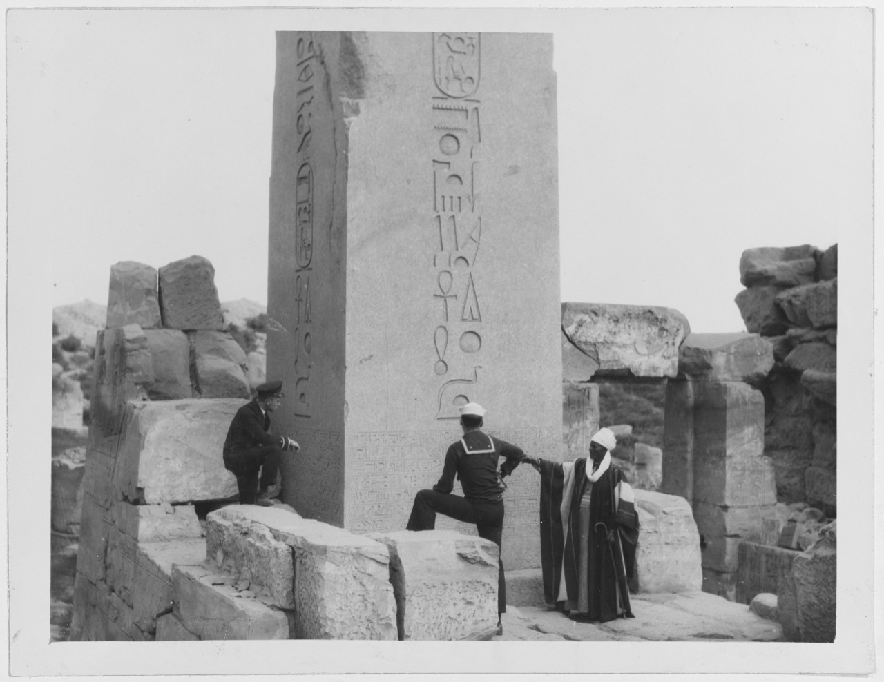 Naval Officer and Bluejacket look at Egyptian obelisk with hieroglyphs