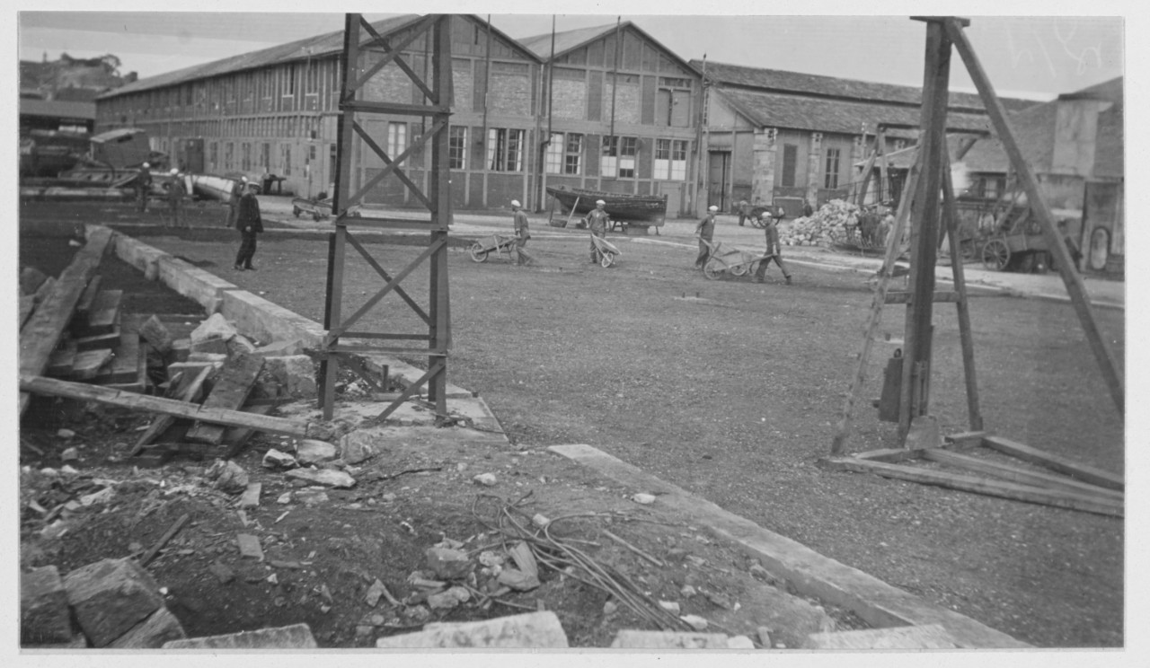 Work shops at Lorient, France. Men push wheelbarrows, buildings in background. Foreign Naval Bases. 1918