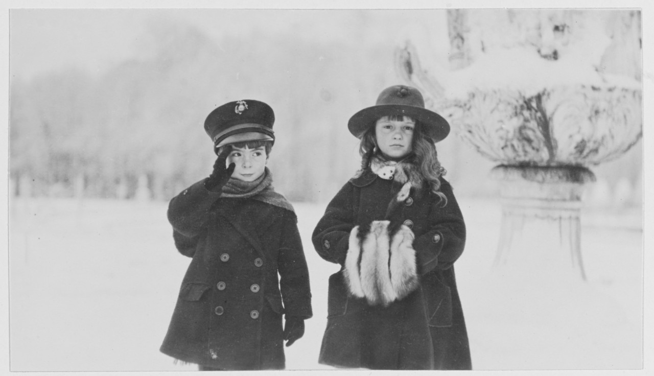 Two young French children pose as Marines at Versailles, France during World War I.