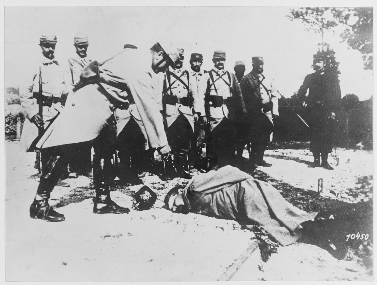 An execution scene in a French prison camp. Soldier holds a gun to the head of a German soldier.
