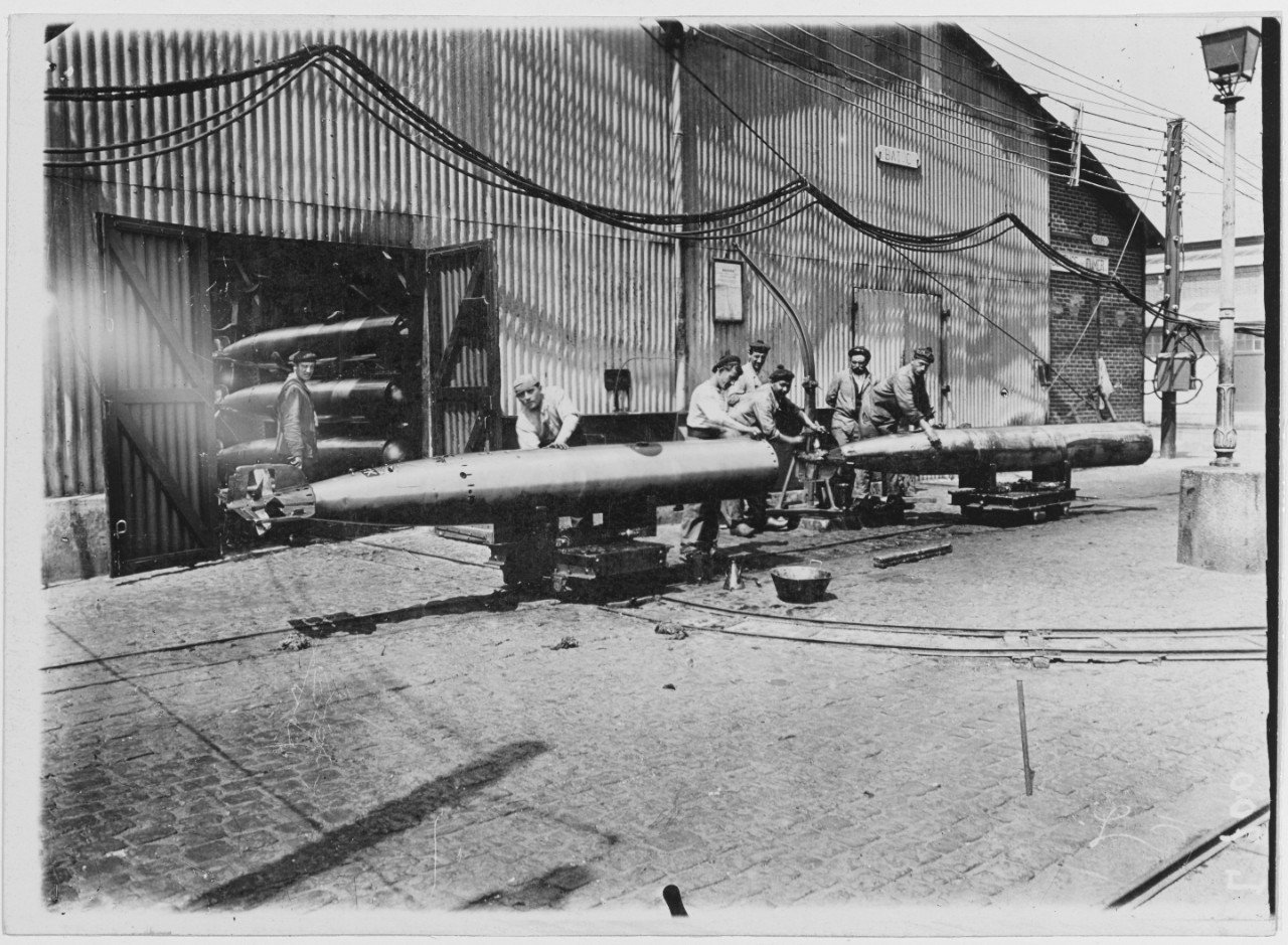 Submarine base, Cherbourg, France. 1918. Condition of torpedoes before firing. Men stand with torpedoes