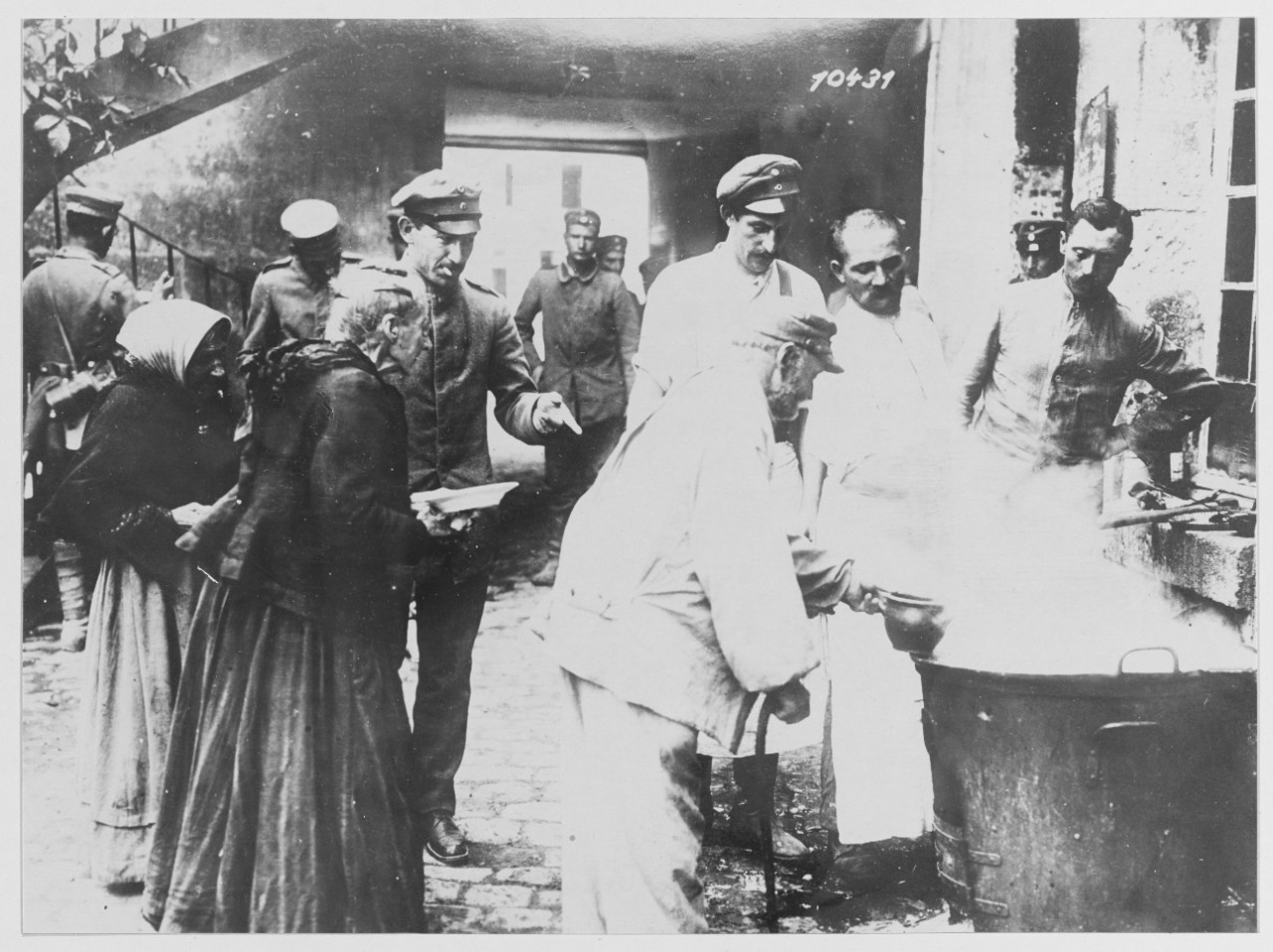 Fugitives from the zone of fire being fed by German Soldiers.