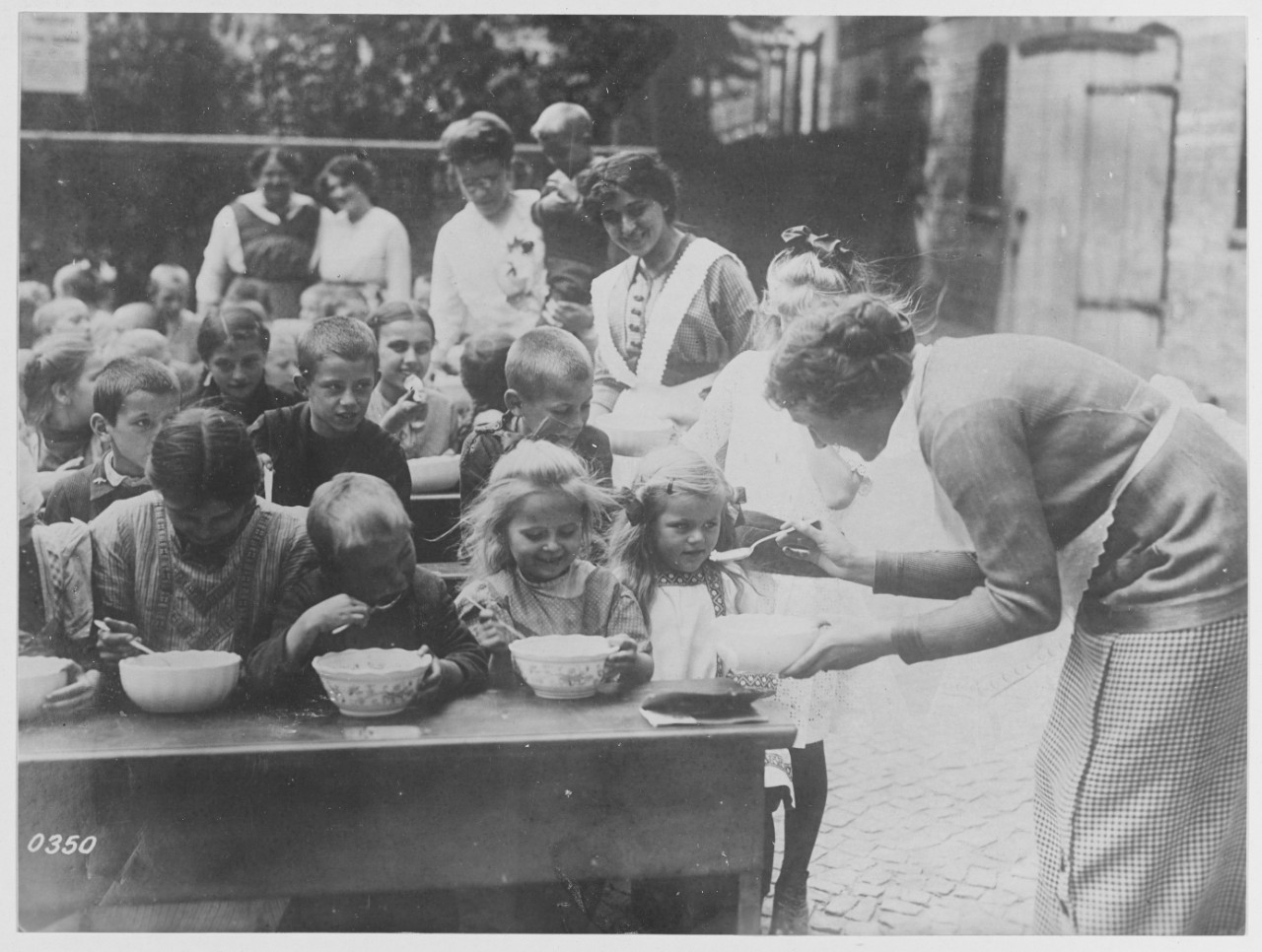 Feeding children of German peasants who have been called to the colors.