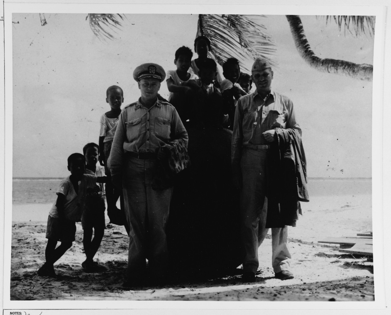 Two Naval officers with a group of native children on Majuro Atoll