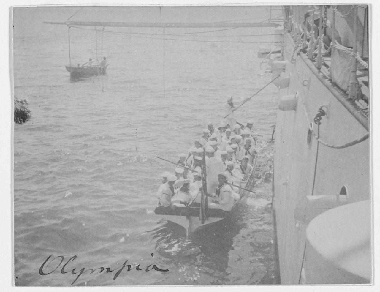 USS OLYMPIA (C-6) launch full of crewmen comes alongside, 1898. 