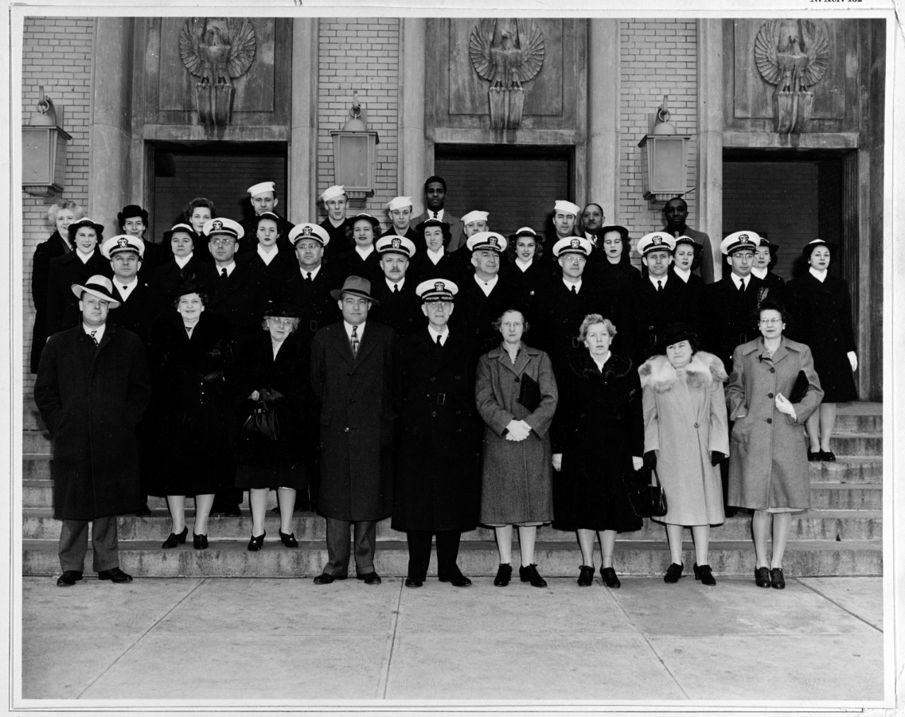 Group photograph of staff of Office of Naval Records and Library (Op-16-E), taken on the steps of the Arlington Navy Annex building, Arlington, Virginia, in April 1944. Front row, center, is Captain Dudley Knox, Officer in Charge.