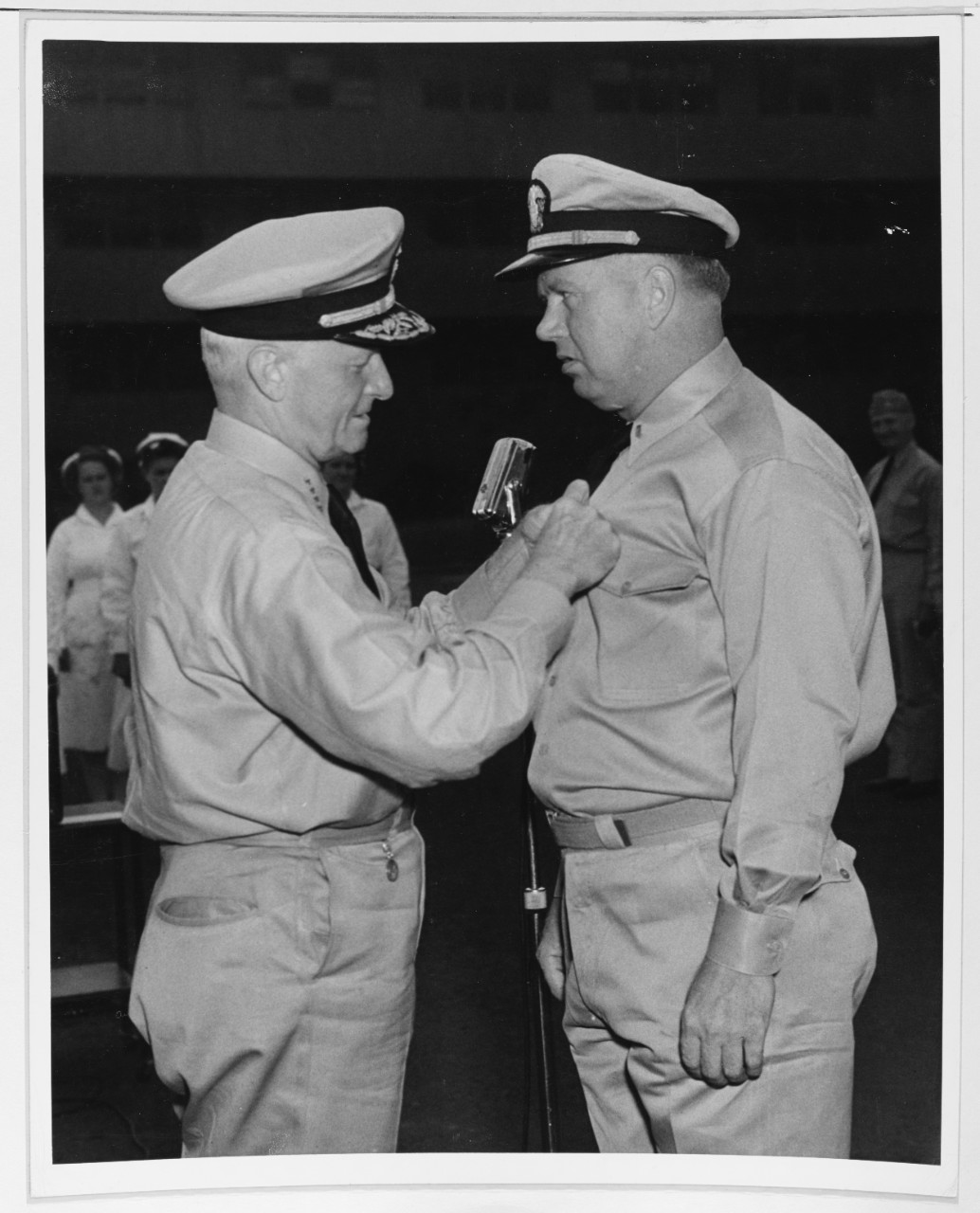 Admiral Chester W. Nimitz (CinCPac-POA) pins the Navy Cross on Lieutenant (jg) D. H. Boyd, USN