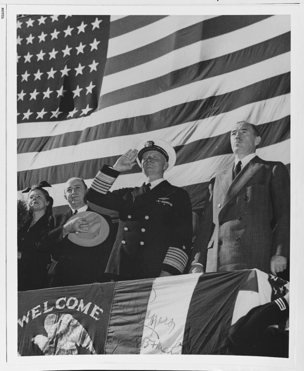 Fleet Admiral Chester W. Nimitz, USN, is shown saluting the colors at a post-war parade in his honor.