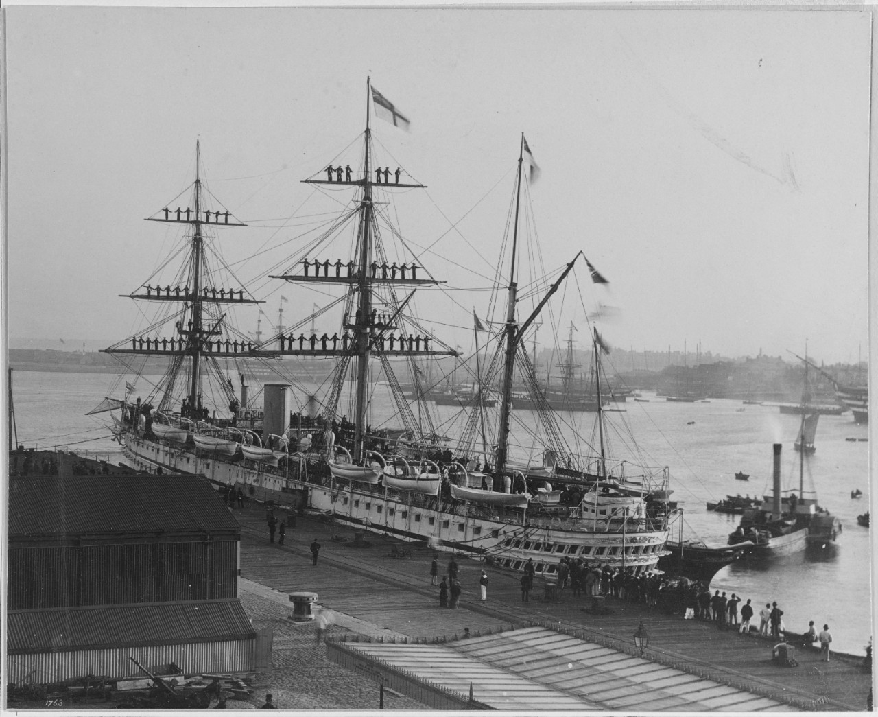 HMS JUMNA (British Transport, 1866) with crew manning the yards.