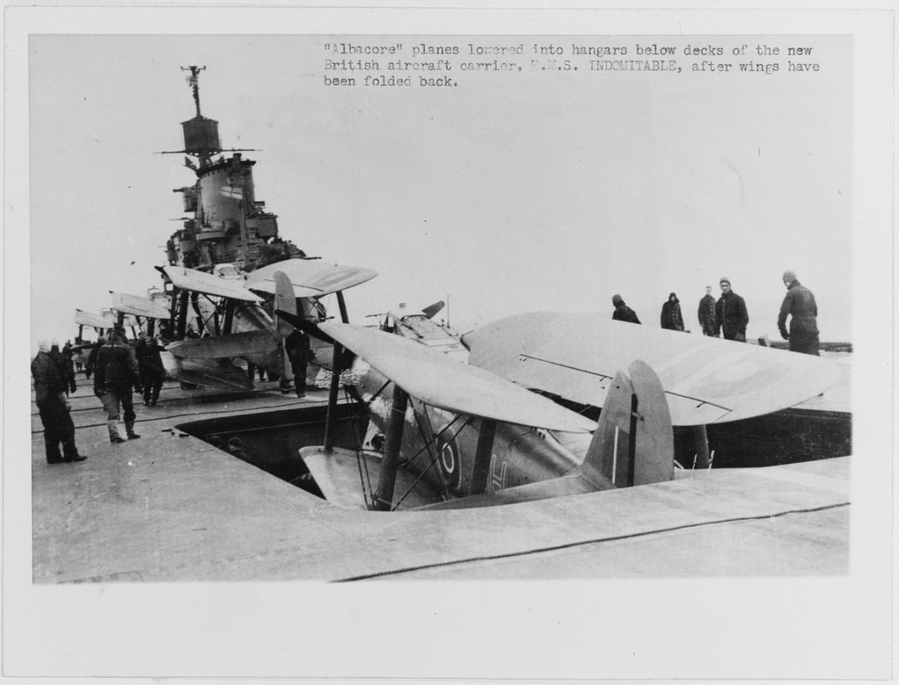 HMS Indomitable - British aircraft carrier, 1940. Striking "Albacore" aircraft below, during WWII. 