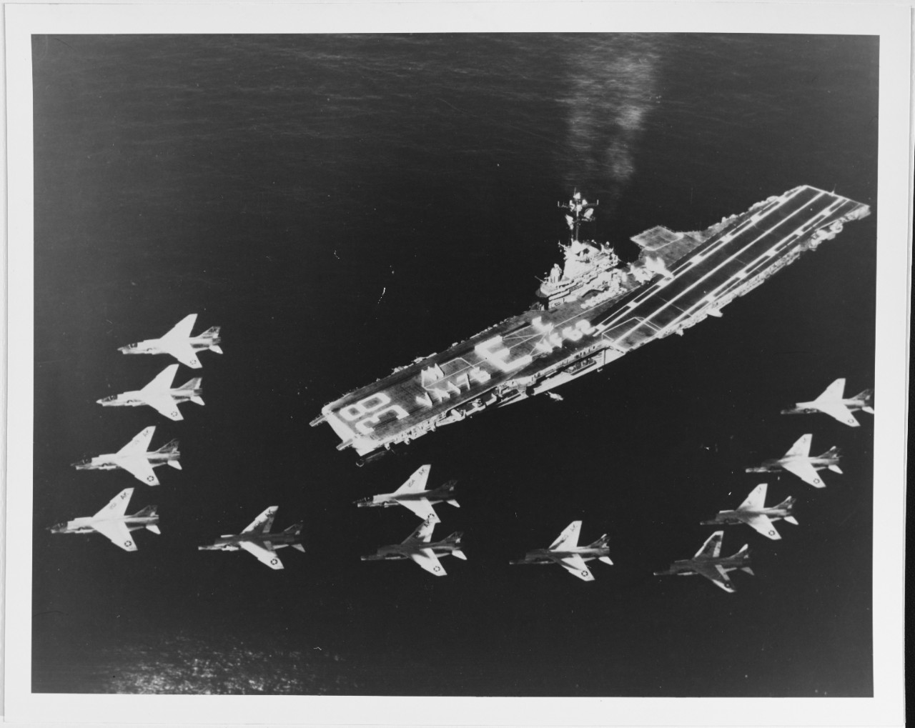 Twelve F8U crusaders of VF-62 pass over USS SHANGRI-LA (CVA-38)
