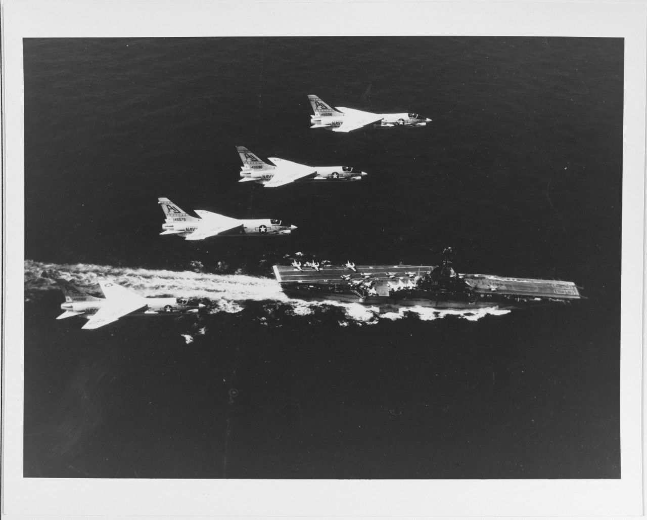 Four F8U crusaders of VF-62 passing over USS SHANGRI-LA (CVA-38)