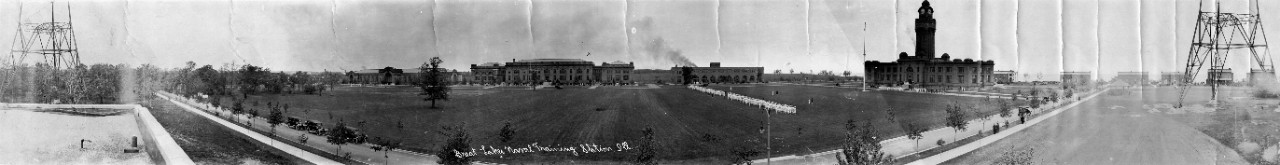 Oversized panoramic of trainees in formation on the parade ground and in front of the central buildings of Naval Training Station Great Lakes, Ill., ca. 1920.