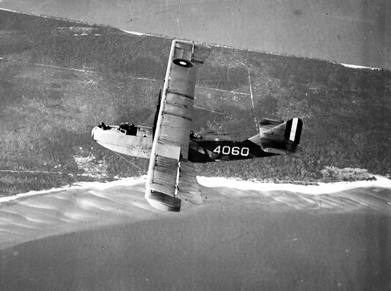 Two photos of US Navy aircraft in flight, circa 1918-1919, including: Curtiss/Burgess N-9/N-9H (Bu# A2505) looping inverted over an air station and Curtiss H-16 seaplane (Bu# A4060) flying over a coastline.