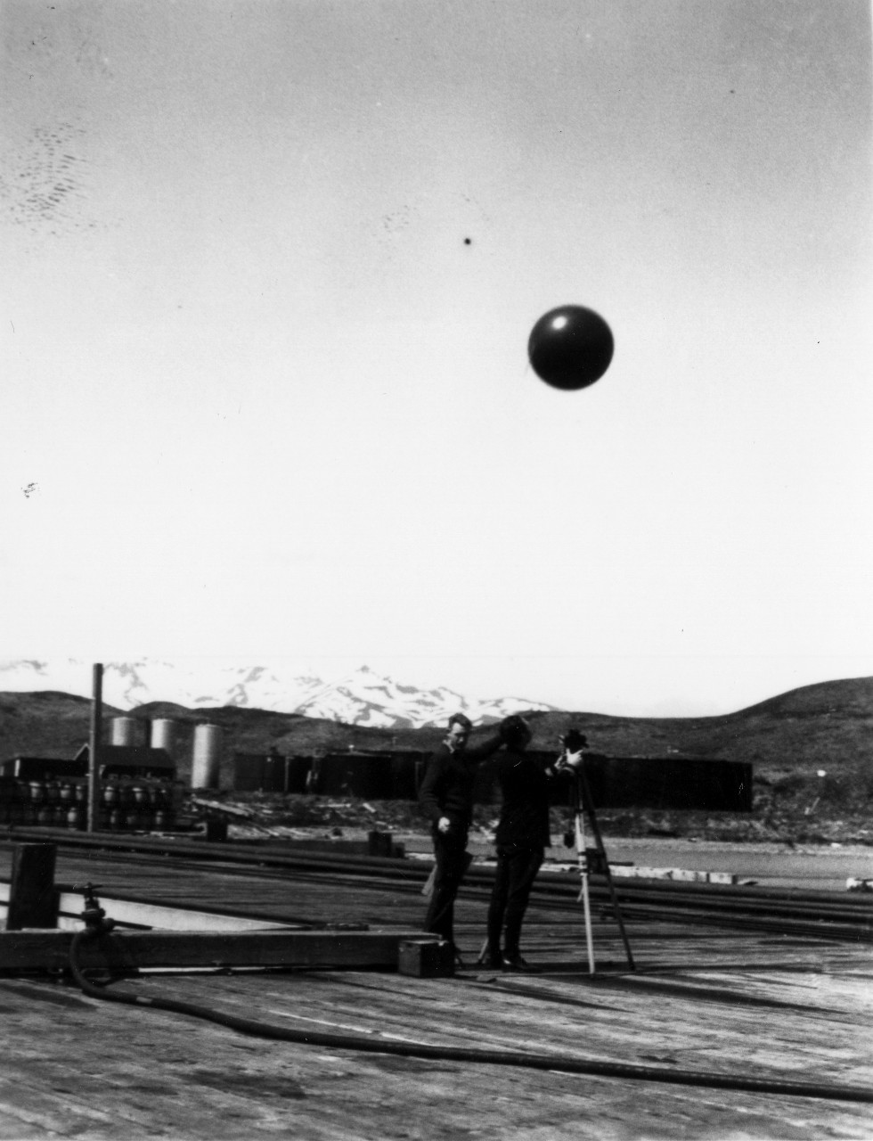 <p>UA 437.04.007 &quot;Taking upper air balloon sounding, Dutch Harbor. Due to the Prevailing cloud ceiling and unsteady platform offered by the Gannet at sea, the opportunities for this type of observation were limited&quot;</p>
