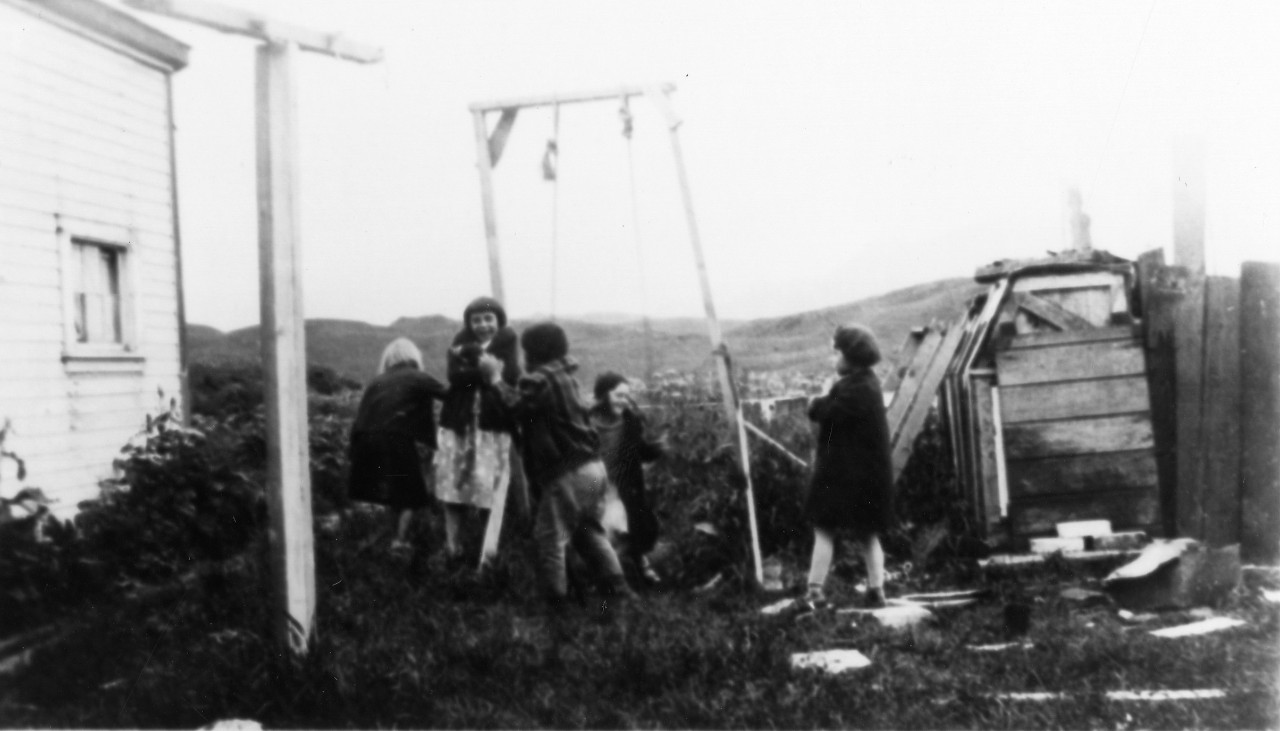 <p>UA 437.04.009 Children of Dutch Harbor snapped in passing. They are healthy, rosy cheeked and active. The tilting of the swing shows the loaminess and dampness of the soil.</p>
