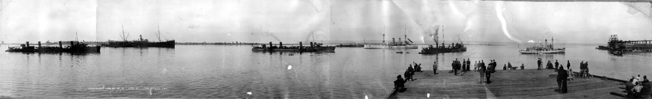 Unidentified ships in a harbor as seen from a pier, 1908. Likely taken along southern California (Long Beach?). 