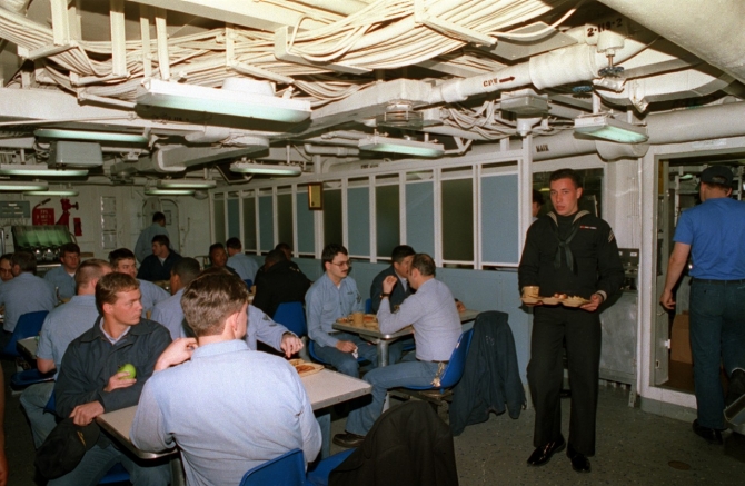 Sailors of the ship’s company and embarked reservists enjoy the noon meal on Ainsworth’s mess decks, 2 February 1992. (CWO2 Ed Bailey, U.S. Navy Photograph 330-CFD-DN-SC-94-01198, Record Group 330 Records of the Office of the Secretary of Defense, 1921–2008, National Archives and Records Administration)