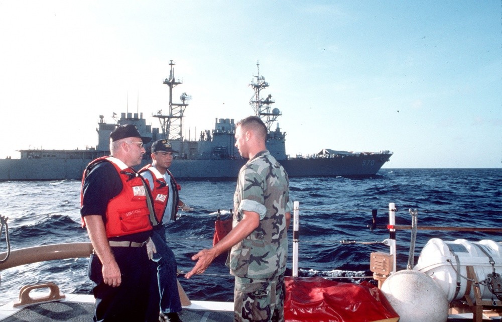 Members of a U.S. Coast Guard law enforcement detachment (LEDET) and a Navy sailor discuss plans during Operation Able Vigil off the coast of Cuba; Caron in background. Note shelter set up on the ship’s bow, 19 September 1994. (U.S. Coast Guard P...