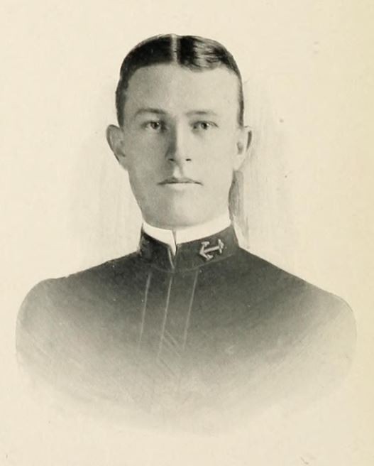 Portrait of William Peace Gaddis, a young Caucasian male wearing a U.S. Navy midshipman uniform, anchor on collar visible on right side of photo.  Photo taken from 1905 U.S. Naval Academy's yearbook, 'Lucky Bag', page 57.